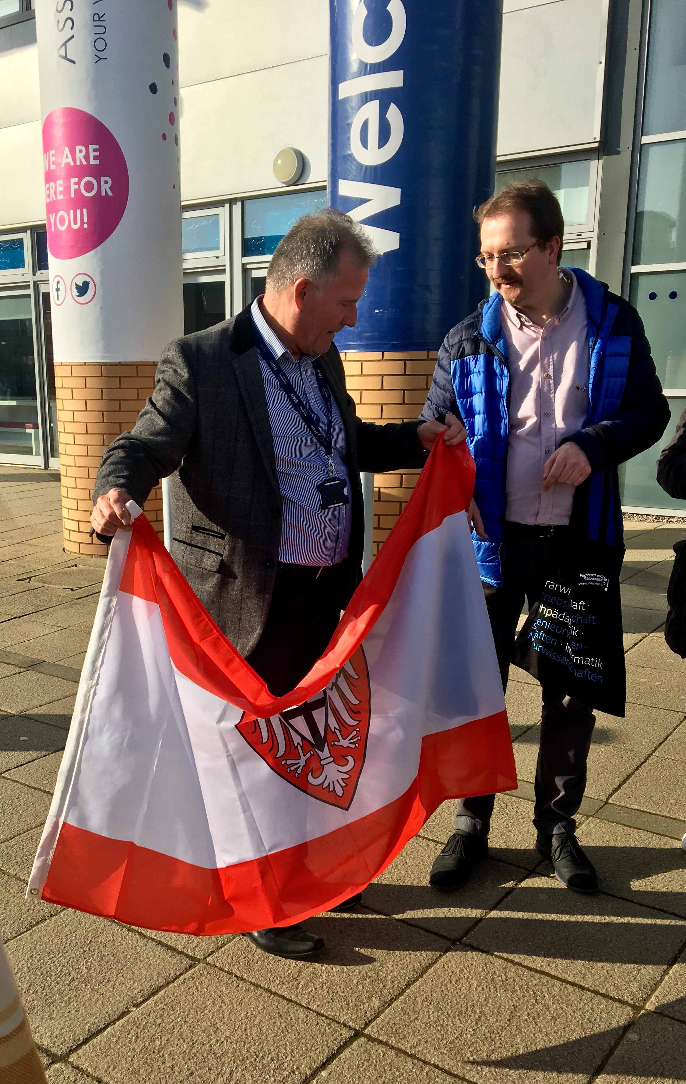 A HSK flag presented by HSK college tutor Neil Davie (on right) to WL College
      host Colin Miller